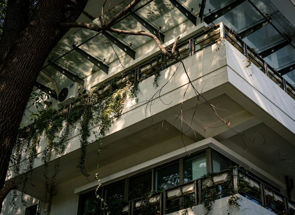 Modern building with balconies and hanging plants.