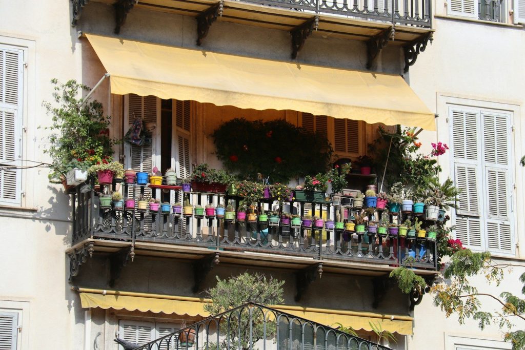 Balcon cu ghivece de flori colorate și plante verzi